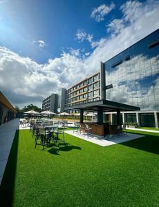 a building with tables and chairs on the grass at Resort Xangri-la Piscina aquecida in Xangri-lá