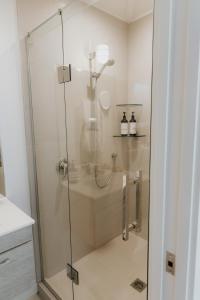 a shower with a glass door in a bathroom at The Boatshed Big Manly in Whangaparaoa