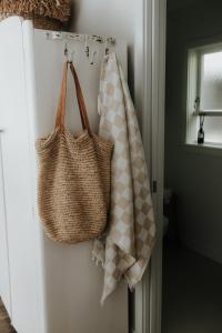 a towel and a tote bag hanging on a refrigerator at The Boatshed Big Manly in Whangaparaoa