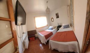 a hotel room with two beds and a flat screen tv at Quemanta Puq in Punta Arenas +1 photo