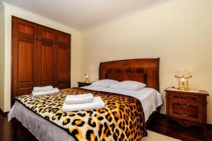 a bedroom with a leopard print bed with two towels at Bela Vale Nº4 in Ribeira Brava