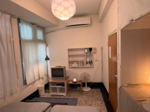 a room with a bed and a television in it at 可以住Canlive中西區海安路包棟民宿-一日只接待一組 in Tainan