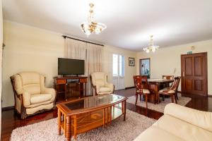 a living room with a tv and a table at Bela Vale Nº4 in Ribeira Brava
