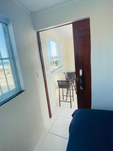 una stanza con una porta, un tavolo e delle sedie di Mini Casa - Orla - 8 Janelas Vista Mar! a Salvador