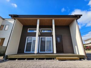a house with three columns on the front of it at Onasyas-A in Hakodate