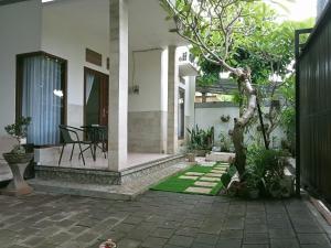 un patio de una casa con una mesa y un árbol en Wihmo Villa Bali, en Nusa Dua