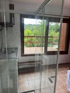 a glass shower in a bathroom with a balcony at Pousada Minha Rosa Paixão - PRAIA DO ROSA, SC in Imbituba +27 photos