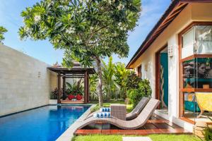 a villa with a swimming pool and a house at Samana Villas in Legian