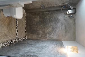 a shower in a bathroom with a concrete wall at Ima House in Ahangama +19 photos