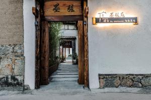 uma entrada para um edifício com uma porta de madeira em 墨弦苑智能轻奢民宿 喜洲镇海舌公园店 em Dali