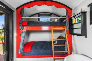 - une chambre avec 3 lits superposés dans une petite maison dans l'établissement Onaeros Cute Little Cottages - Taranaki Retreat, à Waitara