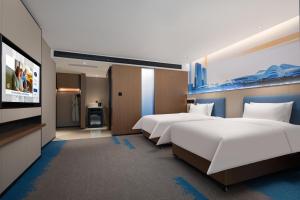 מיטה או מיטות בחדר ב-Hampton by Hilton Changsha Wuyi Square