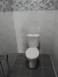 a bathroom with a white toilet and a shower at Melor Guest house in Kampong Telok Dalam