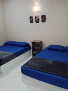 a bedroom with two beds and a night stand at Melor Guest house in Kampong Telok Dalam +4 photos
