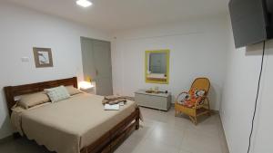 a bedroom with a bed and a chair and a mirror at Apartamento con Jardín Privado en Tarija - Precio al Cambio Oficial in Tarija