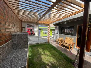 an outdoor patio with a pergola and a lawn at Family Home Furnished Centro Chincha Alta in Chincha Alta