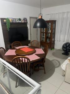 a dining room table with chairs and a black lamp at Casa Panorâmica in Angra dos Reis