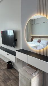a bedroom with a large mirror and a bed at اجنحة افلي in Mogayra