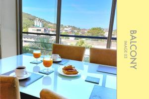 a table with food and two glasses of orange juice at Modern 2-Bedroom Condo in Kamala Near the beach in Kamala Beach