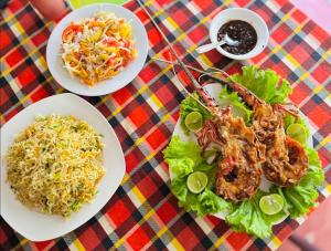 a table topped with plates of food and salad at Nethmi Homestay & family Restaurant in Tangalle
