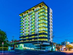 a tall apartment building with lights on at Direct Collective - Pavilion and Governor on Brookes in Brisbane