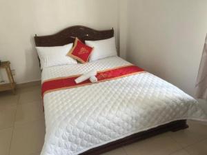 a bed with a white comforter and pillows at Mây Trắng Hotel in Ho Chi Minh City