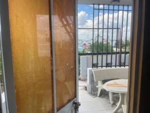 a door to a balcony with a table and a view at Mây Trắng Hotel in Ho Chi Minh City
