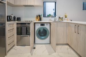 a kitchen with a washing machine in the middle at It's Gettin' HUT in Here in Lower Hutt