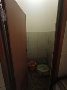 a small bathroom with a toilet and a bucket at Villa Bidadari in Ciater