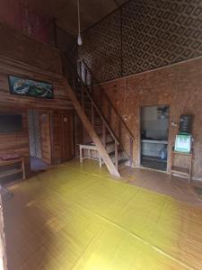 an empty room with a wooden floor and a staircase at Villa Bidadari in Ciater