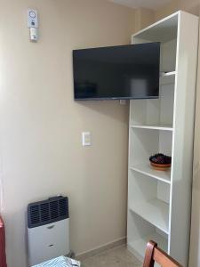 a living room with a tv on a wall at Complejo Médanos in San Bernardo