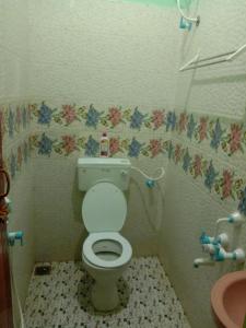 a small bathroom with a toilet and a sink at Thendral sprinkle Home in Puducherry +1 photo