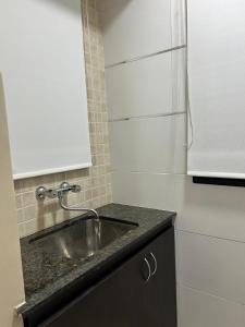 a kitchen with a sink and a white refrigerator at Complejo Médanos in San Bernardo +32 photos