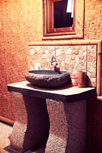 a stone sink on a stone stand with a mirror at Pondok Indah Bungalows Tetebatu in Tetebatu +88 photos