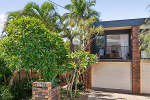 a brick house with a garage and palm trees at Terra Palma - modern unit, aircon, walk to beach in Port Macquarie +2 photos