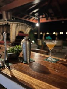a table with a drink and a bowl of greens at Village Paradise in Beliatta