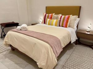 a bedroom with a large bed with colorful pillows at Loft Santorino 4 en Valquirico in Nativitas