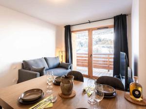 ein Wohnzimmer mit Tisch und Couch in der Unterkunft Neuf T2 avec balcon, parking et casier à skis, idéal pour 4 personnes - FR-1-291-1021 in Valmorel