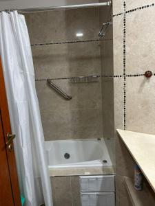 a bathroom with a tub and a shower with a shower curtain at Complejo Médanos in San Bernardo +66 photos