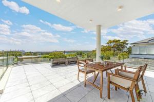 an outdoor patio with a wooden table and chairs at Harbour view new year firework in Sydney