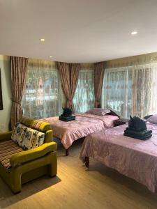 a bedroom with two beds and a couch and windows at Hawaii Lounge in Sihanoukville +79 photos