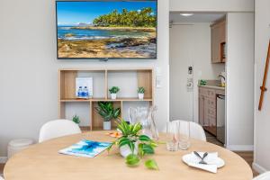 a dining room with a table and a television on the wall at Stylish Studio with Great Ocean Views & Near Beach! in Honolulu