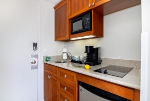 a kitchen with a sink and a microwave at Stylish Studio with Great Ocean Views & Near Beach! in Honolulu