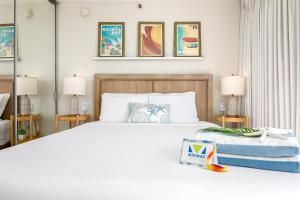 a bedroom with a large white bed and two lamps at Stylish Studio with Great Ocean Views & Near Beach! in Honolulu