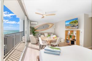 a living room with a table and a balcony with the ocean at Stylish Studio with Great Ocean Views & Near Beach! in Honolulu +37 photos