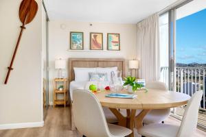 a room with a table and chairs and a bed at Stylish Studio with Great Ocean Views & Near Beach! in Honolulu