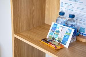 a book and two bottles of water on a shelf at Stylish Studio with Great Ocean Views & Near Beach! in Honolulu