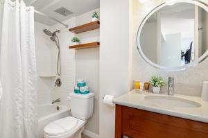 a bathroom with a toilet and a sink and a mirror at Stylish Studio with Great Ocean Views & Near Beach! in Honolulu