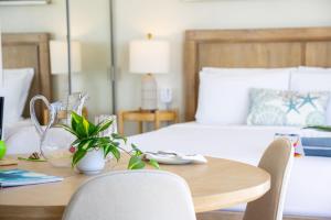 a dining room table with chairs and a bed at Stylish Studio with Great Ocean Views & Near Beach! in Honolulu