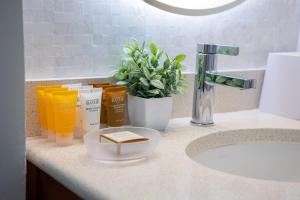 a bathroom counter with a sink and a plant at Stylish Studio with Great Ocean Views & Near Beach! in Honolulu